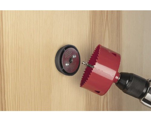 Lochsäge mit Bohrmaschine bohrt ein Loch in eine Holztür