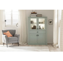 Helles Wohnzimmer mit mintfarbener Vitrine, Sessel und Dekoration