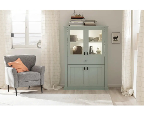 Helles Wohnzimmer mit mintfarbener Vitrine, Sessel und Dekoration