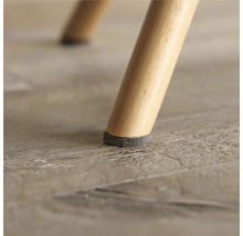 Nahaufnahme eines Stuhlbeins mit Filzgleiter zum Schutz des Bodens.