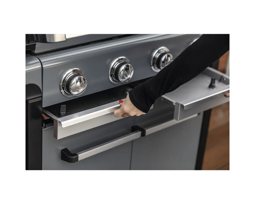 Detailansicht eines Gasgrills mit einer Person, die eine Schublade öffnet