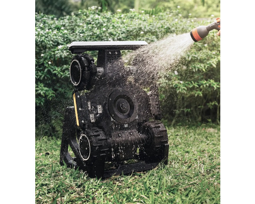 Bewässerter Gartenroboter mit Raupenantrieb im Einsatz auf einer Rasenfläche.