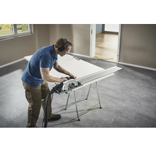 Handwerker sägt eine Tür mit einer Handkreissäge auf einer Werkbank.