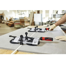 Zwei Fliesenzangen auf einer Fliese mit einer Person im Hintergrund.