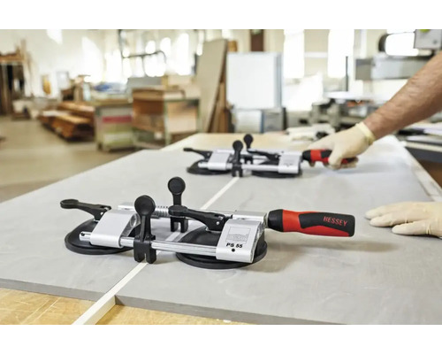 Zwei Fliesenzangen auf einer Fliese mit einer Person im Hintergrund.