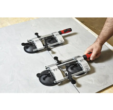 Zwei Fliesenheber mit Vakuumsaugern auf einer Fliese