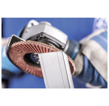 Ein Mann benutzt eine Schleifscheibe an einem Metallstück.