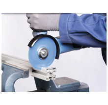 Eine Person schneidet ein Aluminiumprofil mit einem Winkelschleifer in einem Schraubstock.