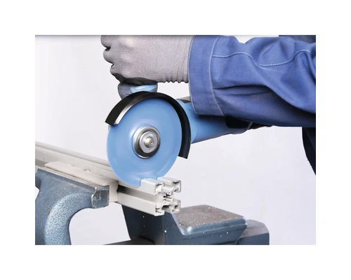 Eine Person schneidet ein Aluminiumprofil mit einem Winkelschleifer in einem Schraubstock.