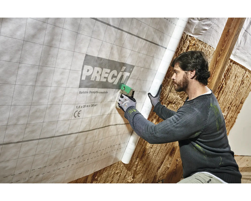 Mann befestigt variable Dampfbremsfolie von Precit mit einem Tacker im Innenbereich.