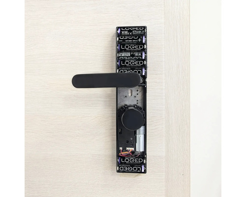 Digitaler Türbeschlag mit Batterien und schwarzem Türgriff an einer Tür.