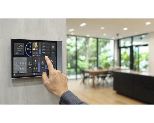 Hand bedient ein Smart-Home-Bedienpanel mit Touchscreen für Temperatur, Musik und Lichtsteuerung in einem hellen, modernen Raum.