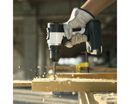 Eine Person bohrt mit einem Akku-Bohrschrauber ein Loch in ein Holzbrett.