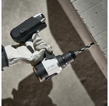 Handwerker bohrt mit einer Akku-Bohrmaschine ein Loch in eine Betonwand.