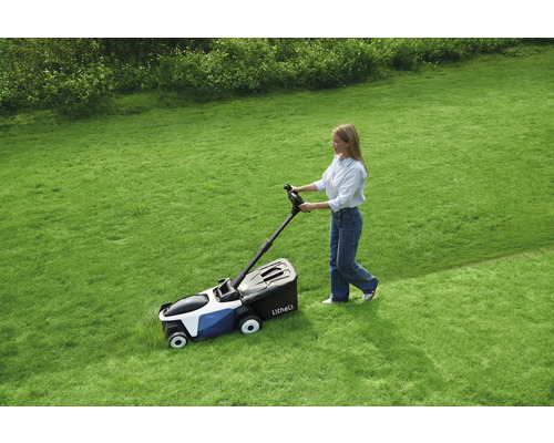 Eine Frau benutzt einen Rasenmäher auf einer Rasenfläche.