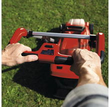 Eine Person bedient einen Rasenmäher auf einer Rasenfläche.