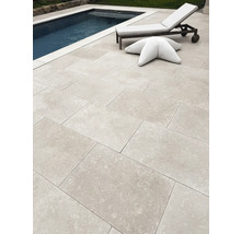 Moderne Terrasse mit großformatigen Steinplatten neben einem Swimmingpool, inklusive Gartenliege und sternförmigem Sitzkissen.