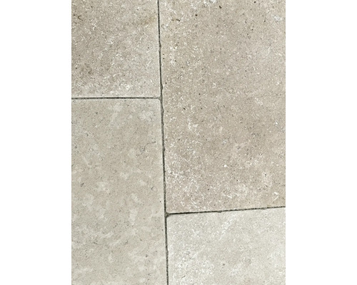 Bodenplatten aus Naturstein mit strukturierter Oberfläche und sichtbaren Fugen.