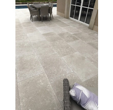 Moderne Terrasse mit Feinsteinzeugplatten in Steinoptik, Sitzgruppe und Pool im Hintergrund.