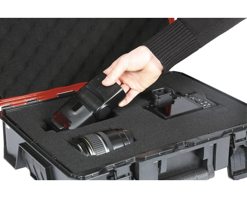 Kameraausrüstung in einem robusten Transportkoffer mit Schaumstoffeinlage für Objektiv, Kamera und Blitzgerät.