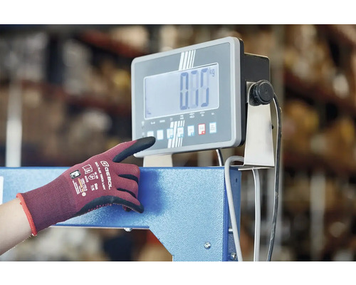 Eine Person bedient eine digitale Industriewaage mit einer Arbeitshandschuh
