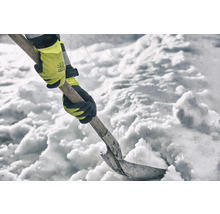 Eine Person schaufelt Schnee mit einer Schneeschaufel und Handschuhen