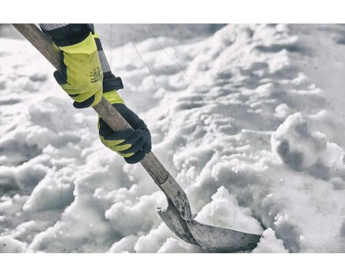 Eine Person schaufelt Schnee mit einer Schneeschaufel und Handschuhen