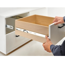 Offener Schubladenauszug an einem weißen Schrank mit Schubladenführung