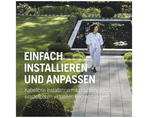 Eine Frau geht in einem Garten mit Teich auf einem Steinweg.