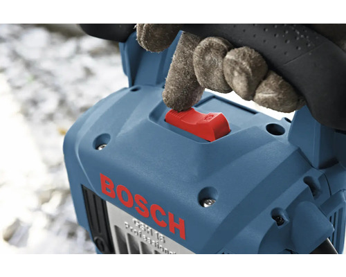 Hand mit Handschuh betätigt den roten Schalter einer blauen Bosch Stemmhammers.