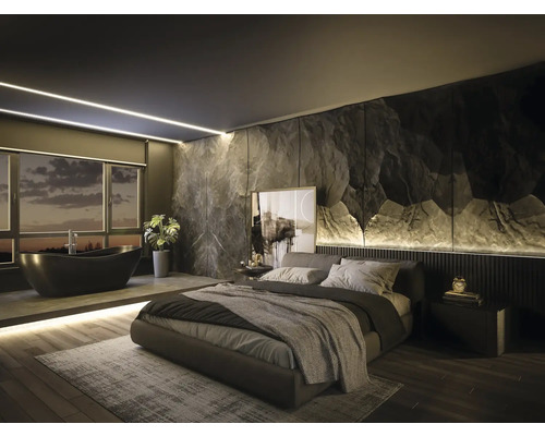 Modernes Schlafzimmer mit integriertem Bad, Akzentwand in Steinoptik, freistehender schwarzer Badewanne und Polsterbett auf Holzboden.