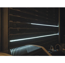 Sichtschutzzaun mit horizontalen Lamellen und integrierten LED-Lichtleisten.