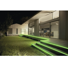 Außenbeleuchtung einer modernen Terrasse bei Nacht mit grünen LED Streifen an den hölzernen Treppenstufen.