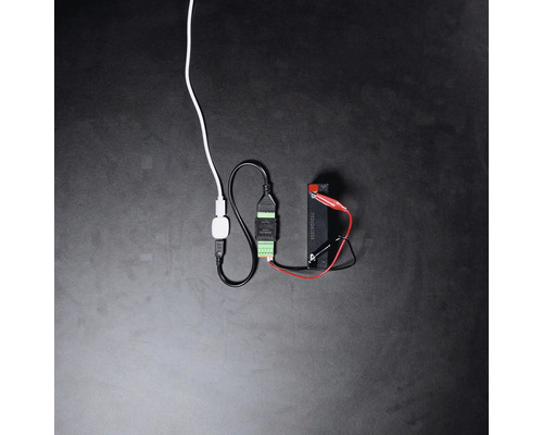 Smart Home Schnittstellenmodul verbunden über Kabel und Krokodilklemmen mit einer Batterie.