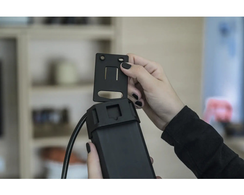 Person befestigt eine Halterung an einem Gerät