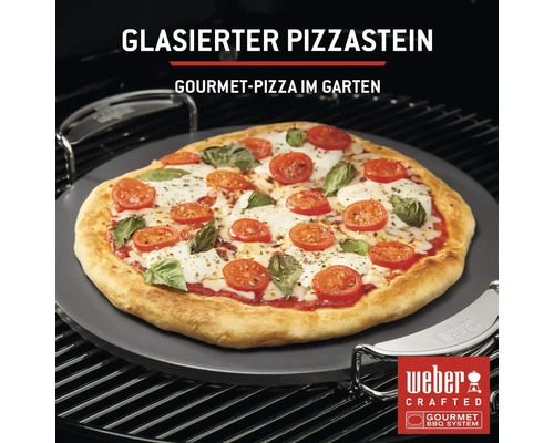 Glasierter Pizzastein mit zubereiteter Pizza auf einem Grill