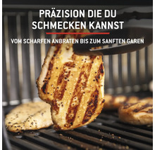 Gegrilltes Hähnchenfleisch auf einem Grillrost wird mit einer Grillzange gewendet.