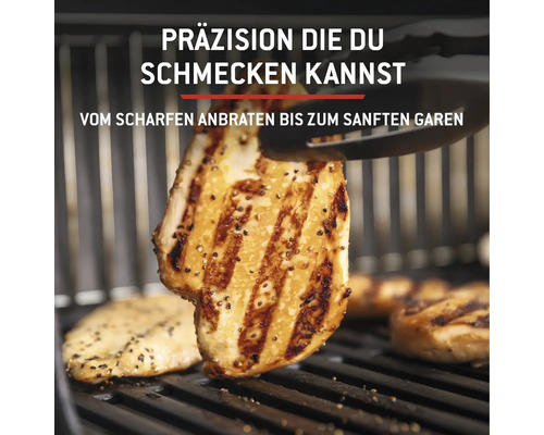 Gegrilltes Hähnchenfleisch auf einem Grillrost wird mit einer Grillzange gewendet.