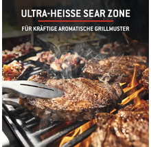 Grill mit Fleisch auf dem Rost und Grillzange