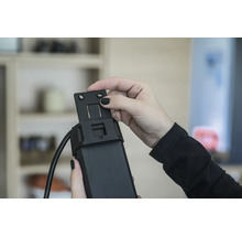 Person montiert eine Halterung an einem Rollladenmotor.