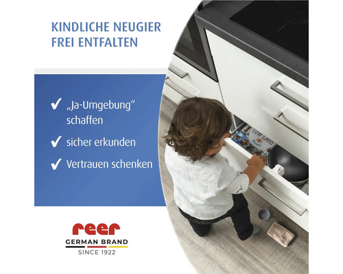 Kind öffnet Schublade mit Kindersicherung in der Küche.