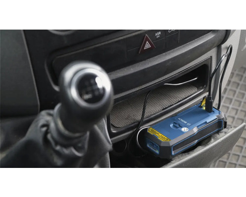 Bosch Ortungsgerät im Ablagefach eines Fahrzeugs mit angeschlossenem Ladekabel