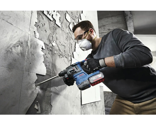 Ein Mann entfernt Fliesen mit einem Bohrhammer von Bosch.