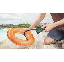 Eine Person pumpt einen Schwimmreifen mit einer Bosch Luftpumpe neben einem Pool auf.