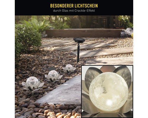 Gartenszene mit Solarleuchten im Blumen-Design und einer Solarleuchte mit Erdspieß