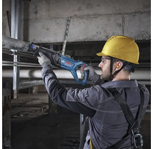 Handwerker mit Schutzausrüstung schneidet ein Metallrohr mit einer Bosch Professional Säbelsäge in einem Rohbau.