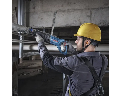 Handwerker mit Schutzausrüstung schneidet ein Metallrohr mit einer Bosch Professional Säbelsäge in einem Rohbau.
