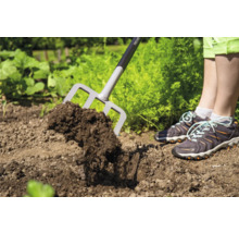 Gartengabel im Einsatz zum Auflockern von Erde im Gartenbeet.