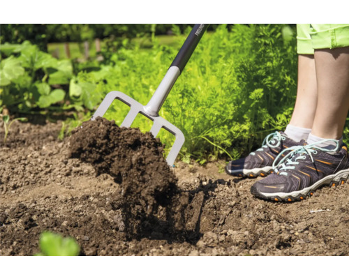 Gartengabel im Einsatz zum Auflockern von Erde im Gartenbeet.