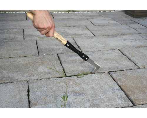Fugenreiniger mit Holzgriff im Einsatz auf Pflastersteinen.